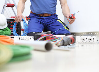 electrician at work with nippers in hand cut the electric cable, install electric circuits, electrical wiring